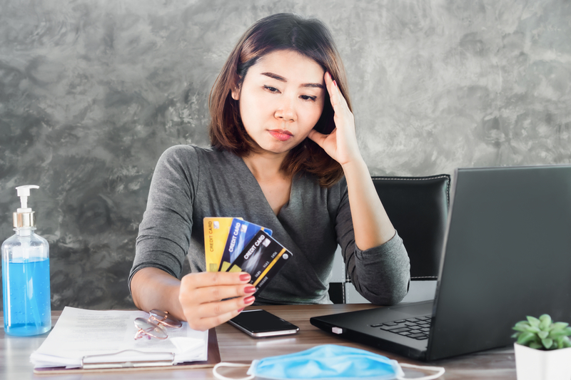 Asian woman in Singapore contemplating how to consolidate her three credit card loans