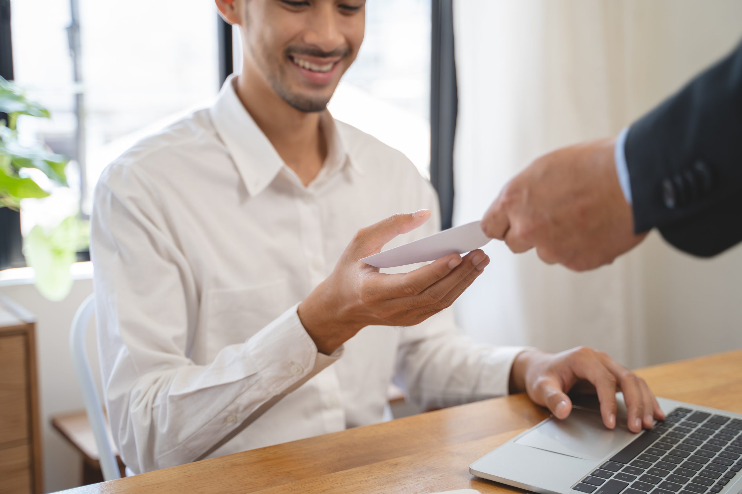 An asian businessman receiving his cash loan in hand after getting his payday advance loan approved