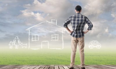 A man looking out at an open space that has chalk drawings of a family, house, and car, representing a person who has personal goals and dreams and wants to apply for a loan.